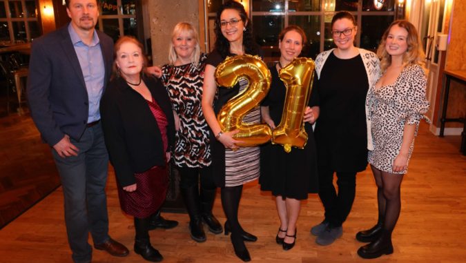 Inova Staff at party holding a 21 balloon.